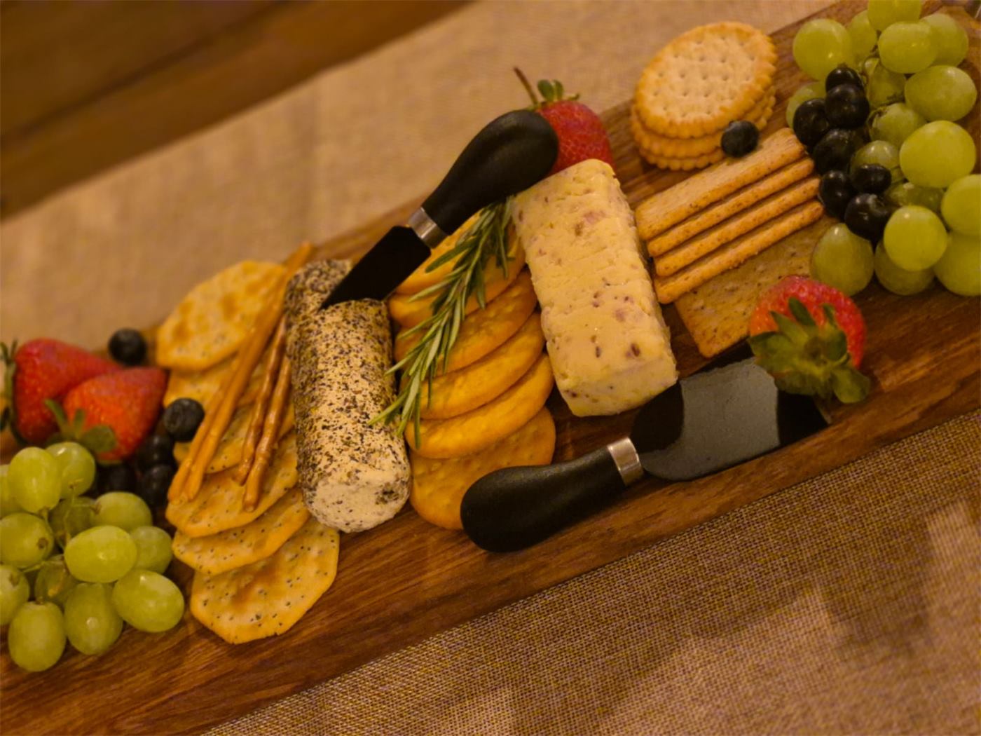 Cheese board with crackers, grapes and strawberries