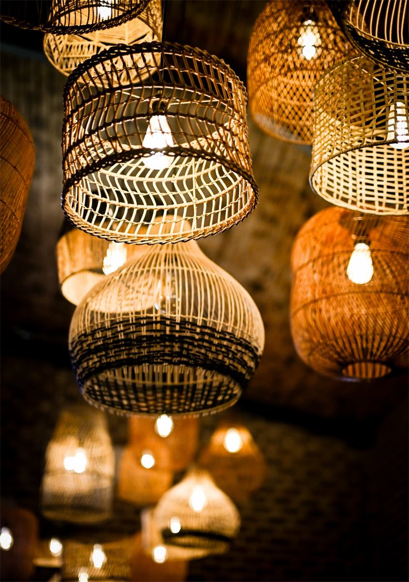 Rattan pendant lamps glowing against a brick wall